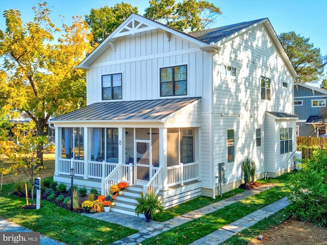 view of front of home featuring a sunroom and a front lawn