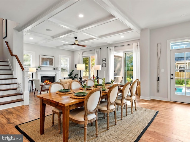 dining area with coffered ceiling, plenty of natural light, and light hardwood / wood-style floors