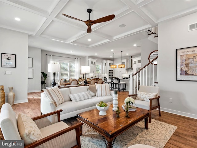 living room with coffered ceiling, beamed ceiling, hardwood / wood-style flooring, and ceiling fan