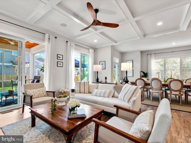 living room with ceiling fan, coffered ceiling, plenty of natural light, and light hardwood / wood-style flooring