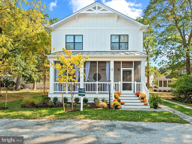 modern farmhouse featuring a sunroom and a front lawn