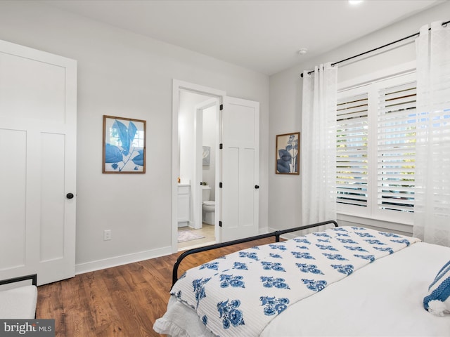 bedroom with ensuite bathroom and dark hardwood / wood-style flooring