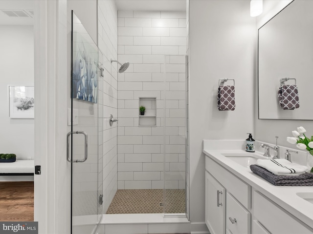 bathroom featuring hardwood / wood-style floors, vanity, and walk in shower