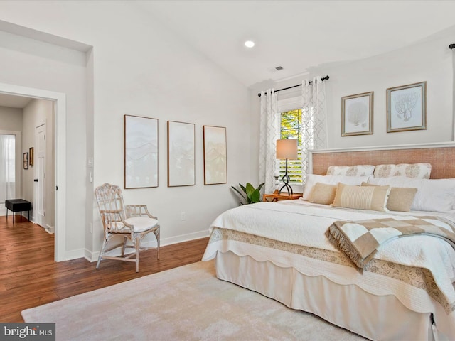 bedroom featuring hardwood / wood-style flooring and vaulted ceiling