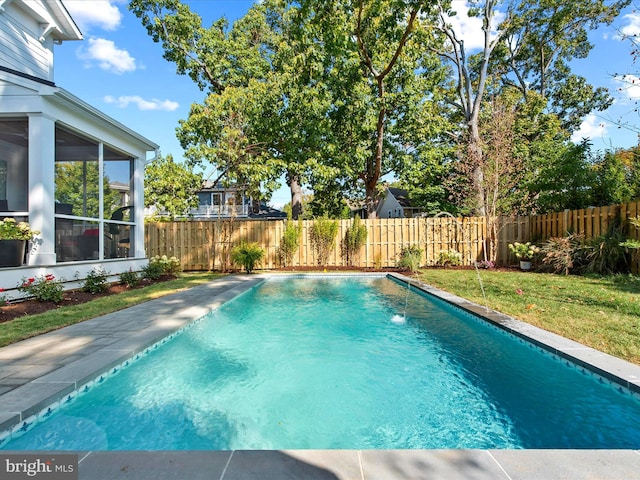 view of swimming pool with a yard, a sunroom, and pool water feature