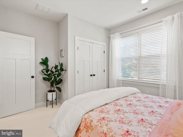 bedroom with light carpet and a closet