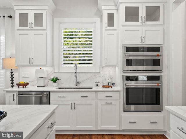 kitchen with appliances with stainless steel finishes, dark hardwood / wood-style flooring, sink, and white cabinets