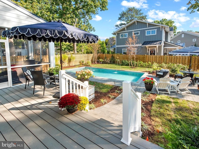 view of swimming pool with a wooden deck and a patio area