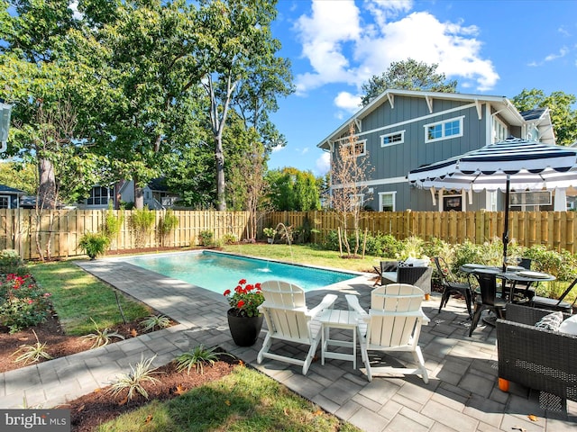 view of pool with a lawn and a patio area