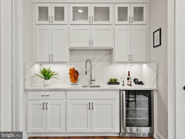 bar with white cabinets, hardwood / wood-style flooring, sink, wine cooler, and backsplash