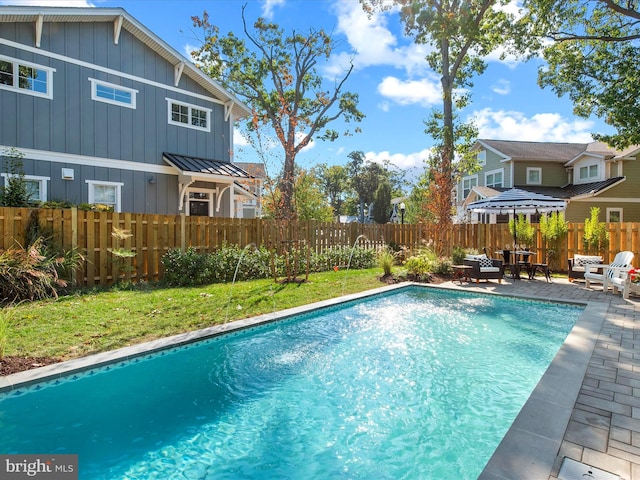 view of swimming pool with a lawn and a patio