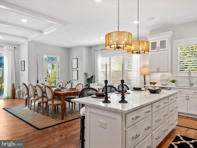 kitchen featuring plenty of natural light, white cabinets, and a kitchen island