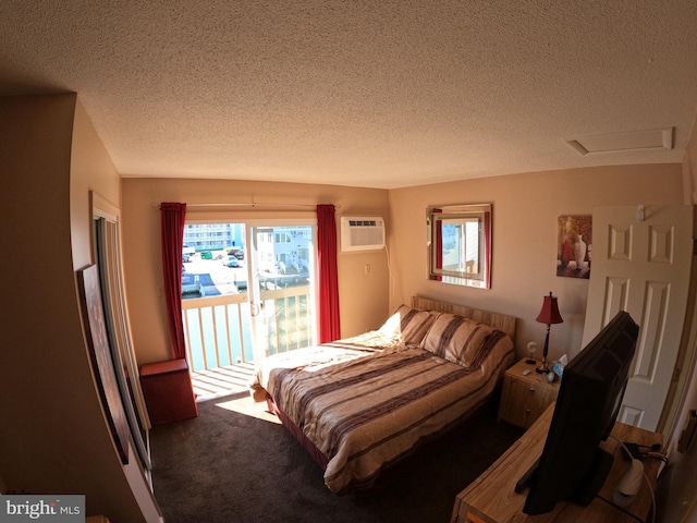 bedroom featuring a wall mounted AC, dark carpet, multiple windows, and a textured ceiling