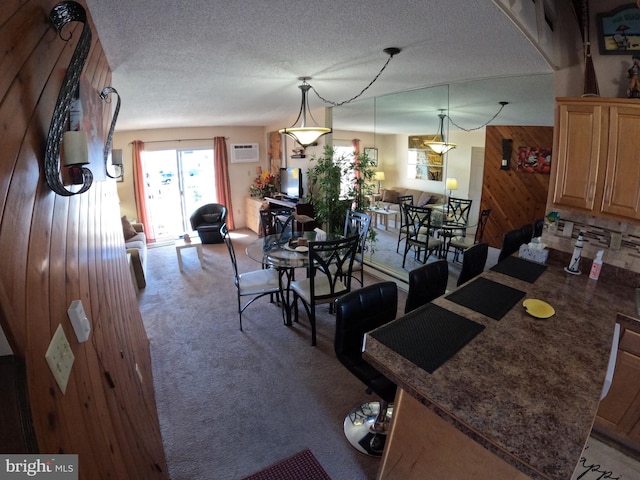 carpeted dining area featuring wooden walls, a wall mounted AC, and a textured ceiling