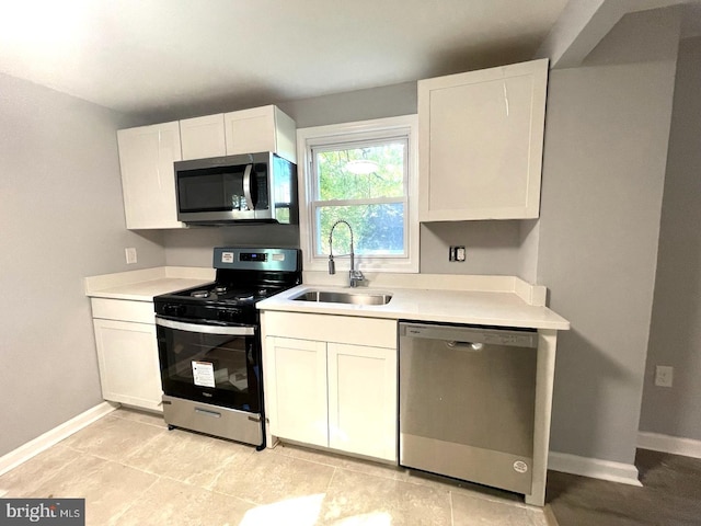 kitchen with appliances with stainless steel finishes, sink, and white cabinetry