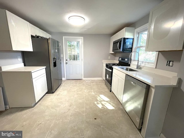 kitchen featuring appliances with stainless steel finishes, white cabinetry, and sink