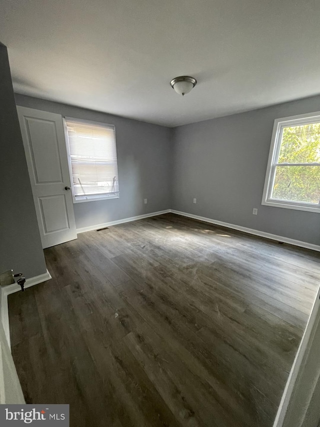 unfurnished room with dark hardwood / wood-style floors