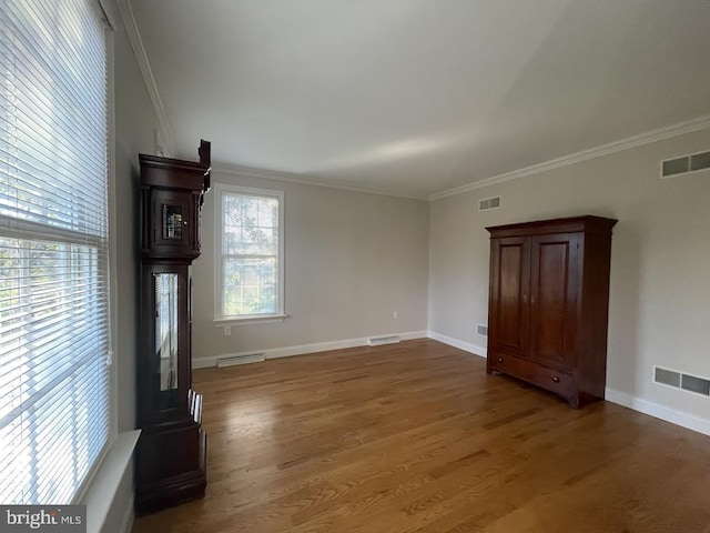 unfurnished living room featuring dark wood-type flooring and crown molding