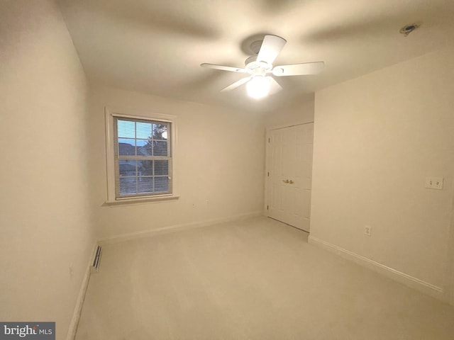 carpeted empty room featuring ceiling fan