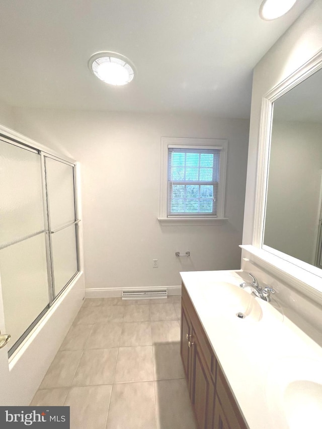 bathroom with tile patterned floors, vanity, and bath / shower combo with glass door