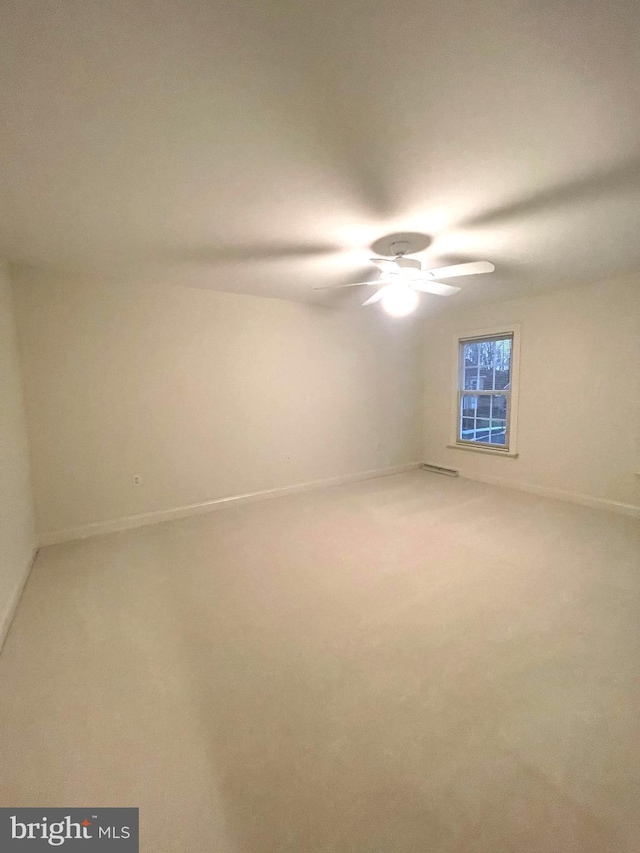 carpeted spare room with ceiling fan