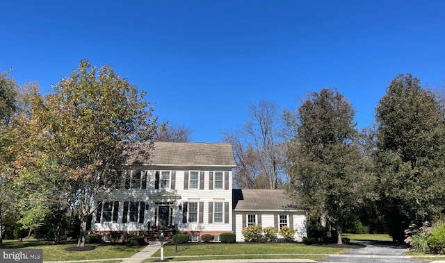 colonial home with a front lawn