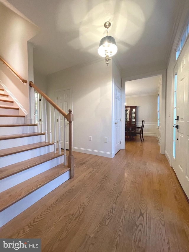 foyer featuring ornamental molding and light hardwood / wood-style flooring