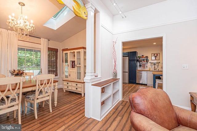 kitchen featuring a skylight, stainless steel appliances, dark wood-type flooring, track lighting, and a chandelier