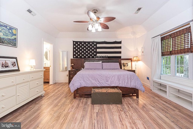 bedroom featuring ceiling fan, ensuite bathroom, and light wood-type flooring