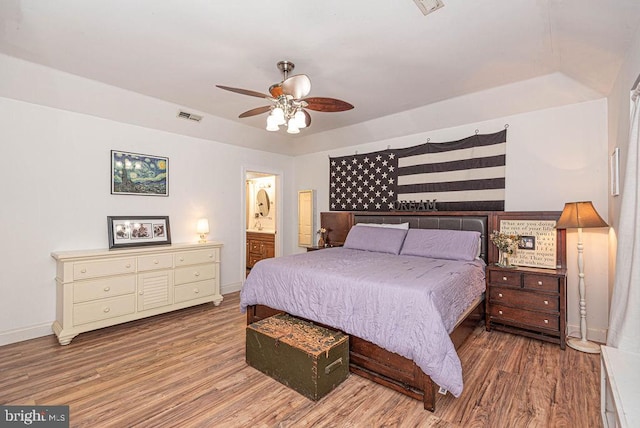 bedroom featuring hardwood / wood-style flooring, connected bathroom, and ceiling fan