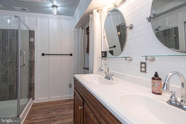 bathroom featuring wood walls, wood-type flooring, an enclosed shower, vanity, and crown molding