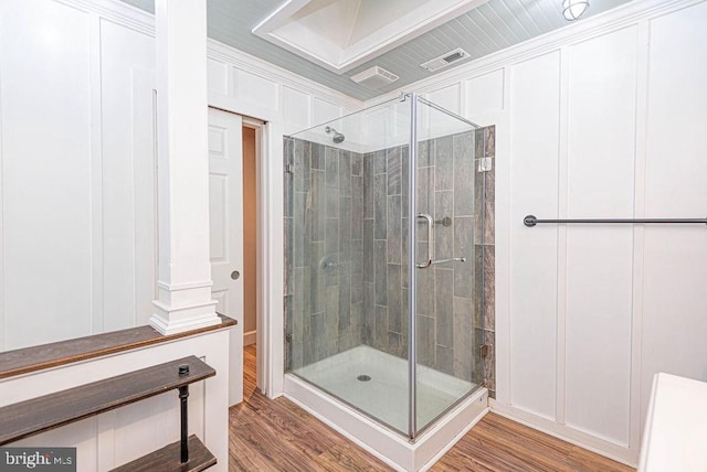 bathroom with decorative columns, hardwood / wood-style flooring, and walk in shower