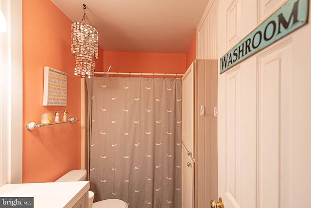 bathroom with vanity, toilet, a notable chandelier, and curtained shower