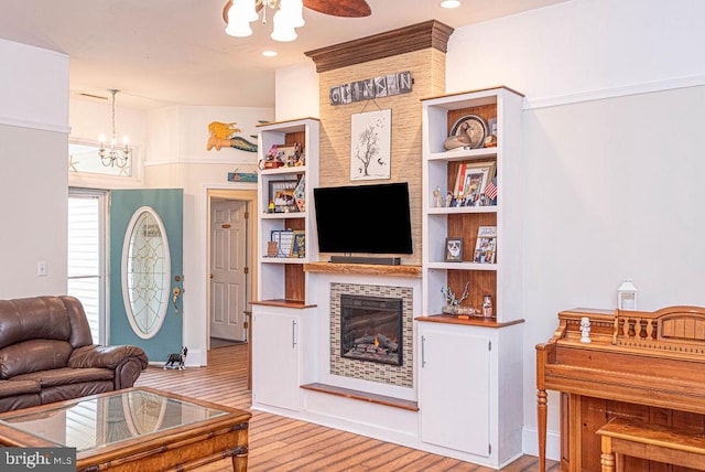 living room with light hardwood / wood-style floors and a notable chandelier