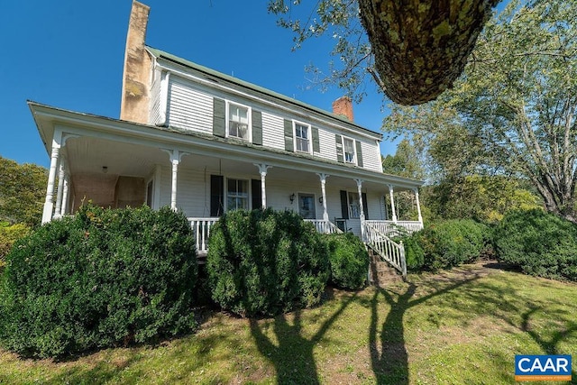 view of front of home with covered porch and a front lawn