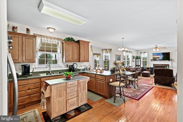 kitchen featuring light hardwood / wood-style floors, sink, a kitchen island, and hanging light fixtures