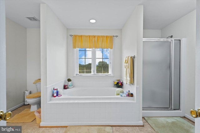 bathroom featuring separate shower and tub, toilet, and tile patterned floors