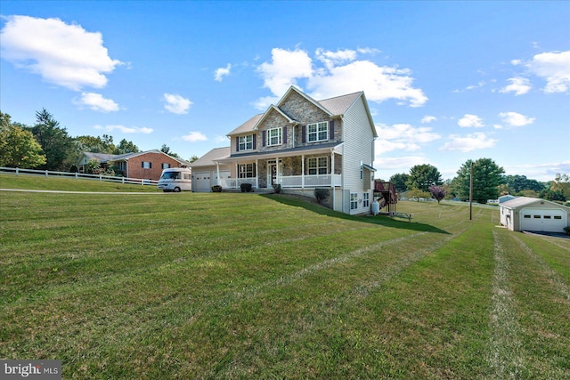 view of front of property featuring a porch, an outdoor structure, a front yard, and a garage