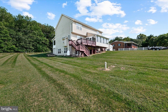 back of house with a deck and a lawn