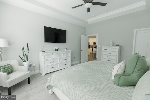 carpeted bedroom with ornamental molding, ceiling fan, and a raised ceiling