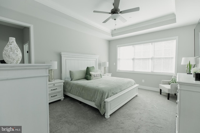 carpeted bedroom featuring ceiling fan, a raised ceiling, and crown molding