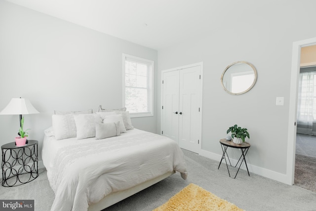 bedroom with light colored carpet and a closet