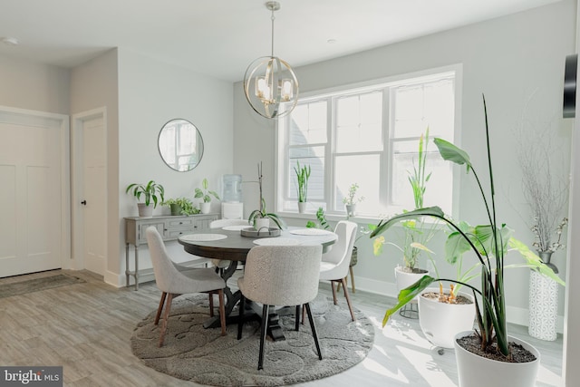 dining area with a notable chandelier and light wood-type flooring