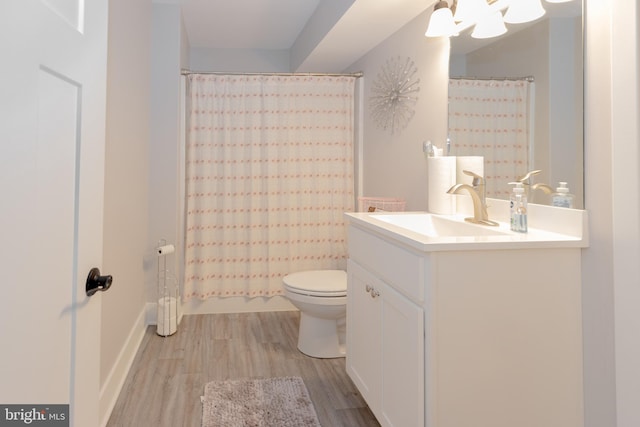 bathroom with curtained shower, vanity, toilet, and hardwood / wood-style flooring