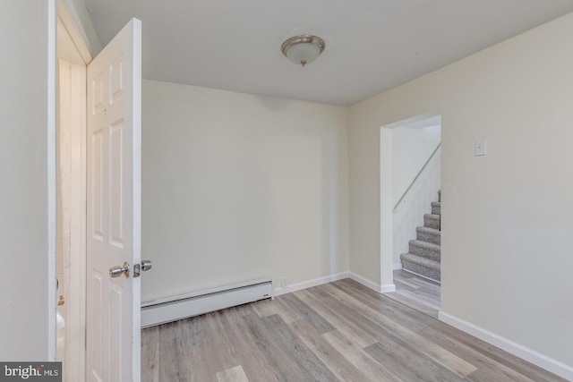 spare room featuring light hardwood / wood-style flooring and a baseboard radiator