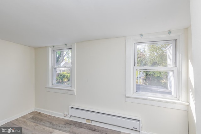 interior space with light hardwood / wood-style flooring and a baseboard heating unit