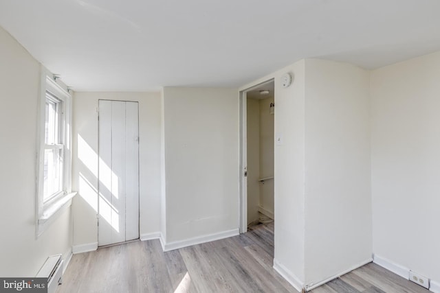 spare room with a baseboard radiator and light hardwood / wood-style flooring