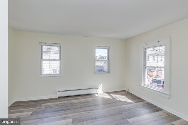 spare room featuring light hardwood / wood-style flooring and a baseboard heating unit