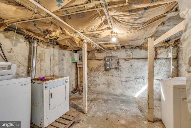 basement featuring electric panel and washer and clothes dryer