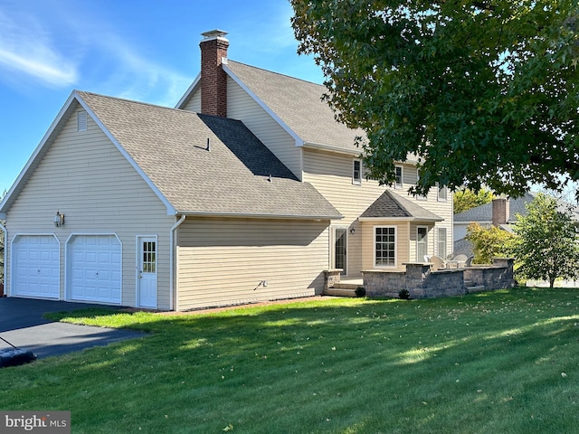 back of house featuring a yard and a garage